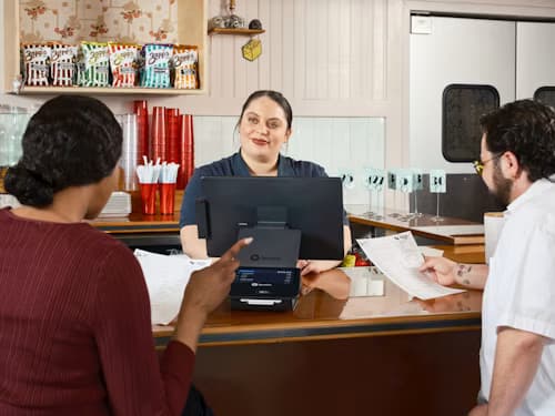 Photo of a staff member working the POS at a retail counter
