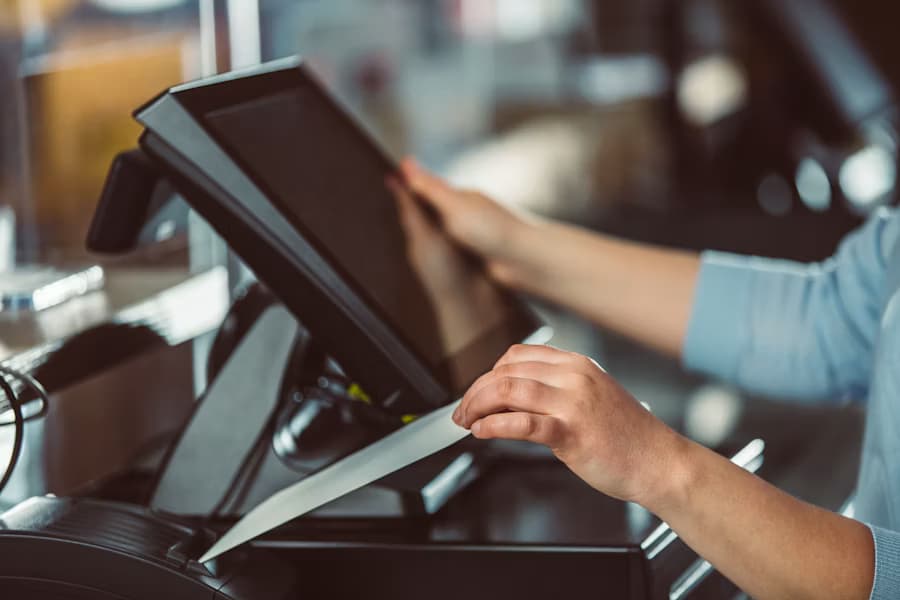 Photo of a staff member using a tablet POS with a card payment terminal