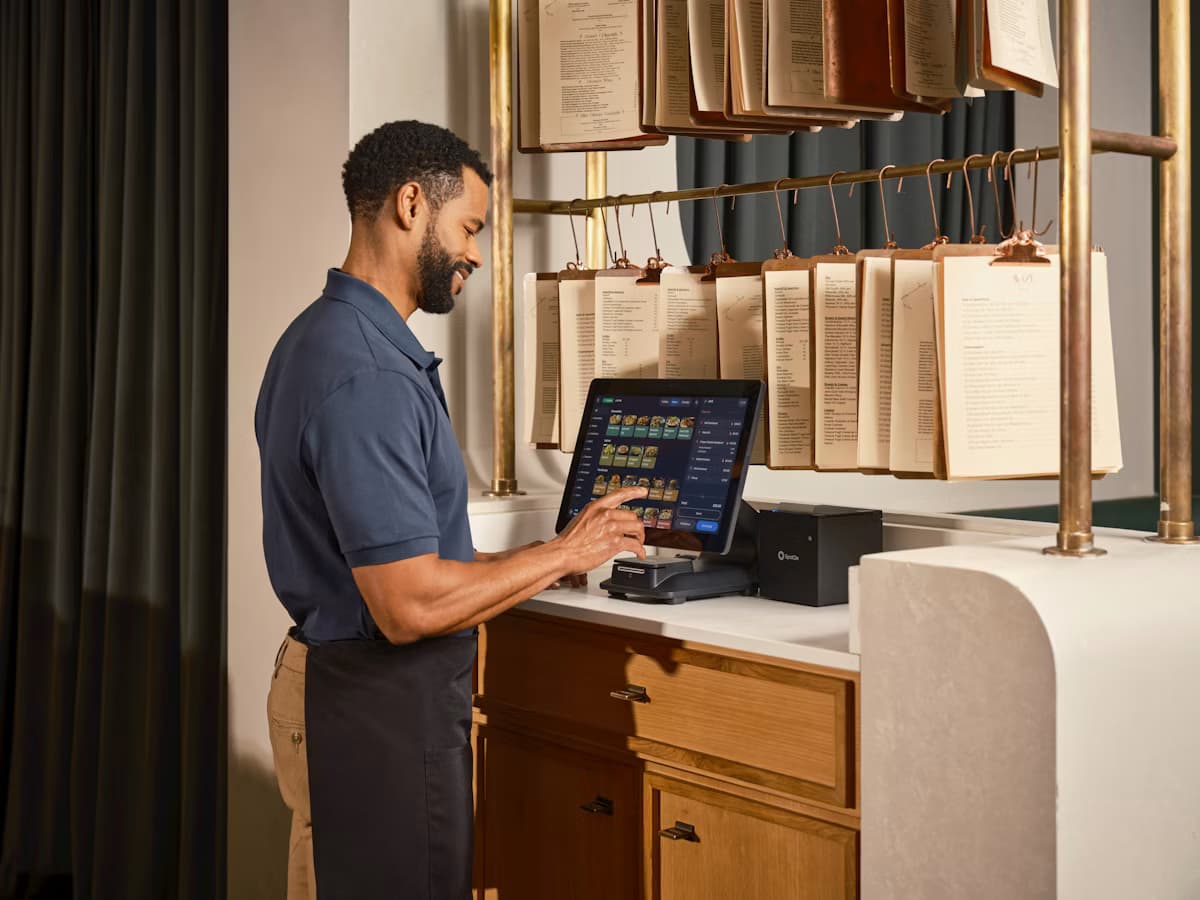 Photo of a store owner operating a point-of-sale system at a stylish checkout counter
